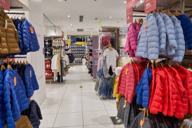 SHENZHEN, ÇİN - CIRCA NOVEMBER, 2019: Shenzhen 'deki Uniqlo mağazasında giysi sergileniyor. Uniqlo bir Japon günlük giyim tasarımcısı, üretici ve perakendecisi..