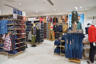 SHENZHEN, ÇİN - CIRCA NOVEMBER, 2019: Shenzhen 'deki Uniqlo mağazasında giysi sergileniyor. Uniqlo bir Japon günlük giyim tasarımcısı, üretici ve perakendecisi..