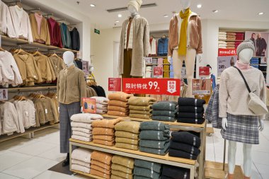 SHENZHEN, ÇİN - CIRCA NOVEMBER, 2019: Shenzhen 'deki Uniqlo mağazasında giysi sergileniyor. Uniqlo bir Japon günlük giyim tasarımcısı, üretici ve perakendecisi..