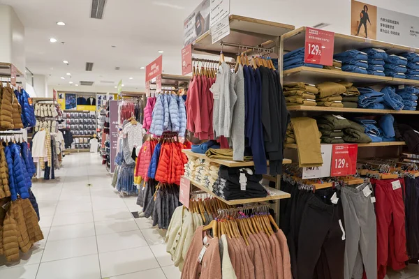 SHENZHEN, ÇİN - CIRCA NOVEMBER, 2019: Shenzhen 'deki Uniqlo mağazasında giysi sergileniyor. Uniqlo bir Japon günlük giyim tasarımcısı, üretici ve perakendecisi..