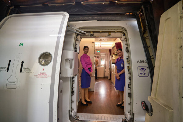 PHUKET, THAILAND - CIRCA JANUARY, 2020: crew members meet passengers in Thai Airways Airbus A350 at Phuket International Airport.