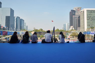 SHENZHEN, ÇİN - 27 Kasım 2019: İnsanlar Moda Kaynağı sırasında Shenzhen Kongre ve Sergi Merkezi 'nin merdivenlerinde oturuyorlar..