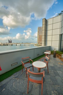 ABU DHABI, BAE - CIRCA JANUARY, 2020: Arka planda Abu Dabi kentsel manzaralı masa ve sandalyelerin manzarası.