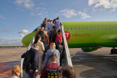 MOSCOW, RUSSIA - CIRCA SEPTEMBER, 2019: Moskova Domodedovo Havaalanı 'ndan S7 uçağına binen insanlar.