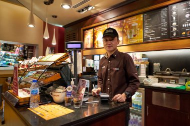 ABU DHABI, BAE - CIRCA JANUARY, 2020: Abu Dabi Uluslararası Havalimanı Costa Coffee 'deki çalışanın kapalı bir portresi. 