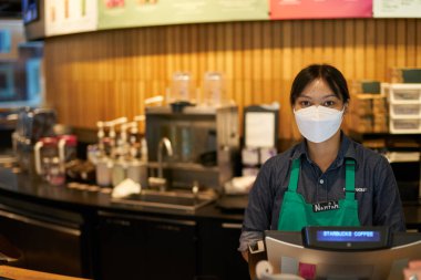 BANGKOK, THAILAND - CIRCA APRIL, 2023: Siyam Discovery alışveriş merkezindeki Starbucks Kafe bakan, çalışan portresi.