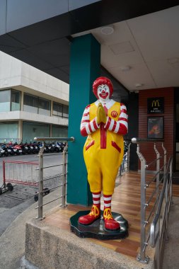 PATTAYA, THAILAND - CIRCA APRIL, 2023: Pattaya 'daki McDonald' s restoranında müşterileri geleneksel Tayland selamı ile selamlayan gerçek boyuttaki Ronald McDonald heykeli.