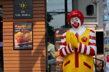 PATTAYA, THAILAND - CIRCA APRIL, 2023: Pattaya 'daki McDonald' s restoranında müşterileri geleneksel Tayland selamı ile selamlayan gerçek boyuttaki Ronald McDonald heykeli.