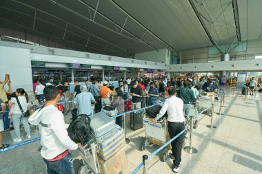 HO CHI MINH CITY, VİETNAM - CIRCA MARCH, 2023: Yolcular Tan Son Nhat Uluslararası Havaalanı 'nda kontrol kuyruğunda bekliyorlar.