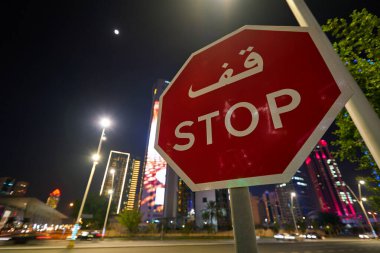 DOHA, Katar - CIRCA MARCH, 2023: Doha 'da gece görülen Stop sokak tabelasının yakın çekimi.