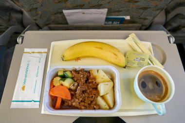 HO CHI MINH CITY, VİETNAM - 24 Mart 2023: Vietnam Havayolları Airbus A321 ekonomi sınıfında yemek servisi.