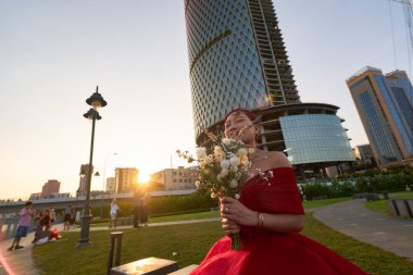 HO CHI MINH CITY, VİETNAM - 25 Mart 2023: Bach Dang Wharf bölgesinde kırmızı elbiseli bir kadının açık hava fotoğrafı.