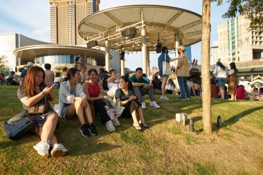 KUALA LUMPUR, MALAYSIA - CIRCA MAYIS, 2023: Mitsui Alışveriş Parkı LaLaport BBCC 'nin 4. katındaki Merkez Çatı Bahçesi' nde insanlar çimlerin üzerinde oturuyor.