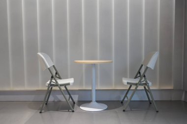 Boş salonda bir masa ve iki sandalye..