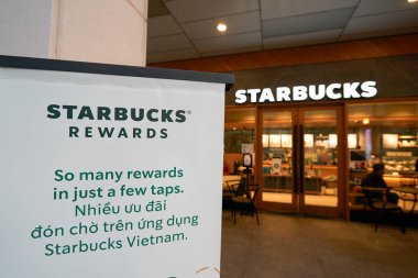 HO CHI MINH CITY, VİETNAM - 29 Mart 2023: Starbucks Ödülleri tabelasının arka planda Starbucks Kahvesi girişi.