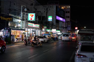 PHUKET, THAILAND - 25 Nisan 2023: Phuket 'te gece vakti 7-Eleven bakkalının sokak manzarası.