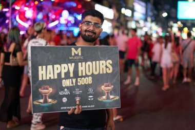 PHUKET, THAILAND - APRIL 25, 2023: man with ad poster on Patong Beach Bangla Walking Street in the night. clipart