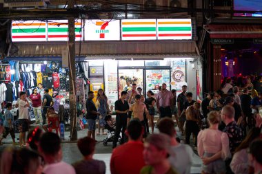 PHUKET, THAILAND - 25 Nisan 2023: Phuket 'te gece vakti 7-Eleven bakkalının sokak manzarası.