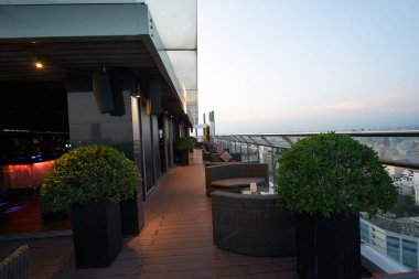 HO CHI MINH CITY, VIETNAM - MARCH 26, 2023: view of outdoor terrace at OnTop Bar, a rooftop bar located on the 20th floor at Novotel Saigon Centre. clipart