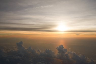 Uçaktan bulutların üzerinden görünen hava görüntüsü.