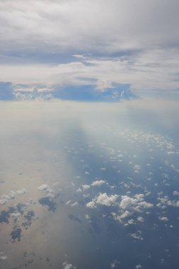 Uçaktan bulutların üzerinden görünen hava görüntüsü.