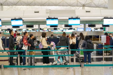 HONG KONG, ÇİN - 04 ARALIK 2023: Hong Kong Uluslararası Havaalanı 'nda bilet kuyruğunda bekleyen yolcular.