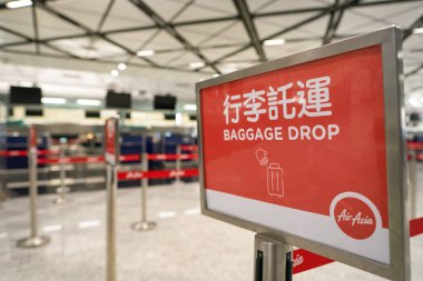 HONG KONG, ÇİN - 04 Aralık 2023: Hong Kong Uluslararası Havalimanı 'ndaki AirAsia check-in alanında görülen bagaj bırakma işaretinin yakın çekimi.