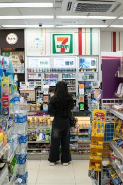 HONG KONG, ÇİN - 07 Aralık 2023: Hong Kong 'daki 7-Eleven bakkalında kadın maaşı.