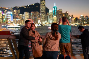 HONG KONG, ÇİN - 07 Aralık 2023: İnsanlar Hong Kong 'daki Yıldızlar Bulvarı' nda gece vakti fotoğraf çekiyorlar..
