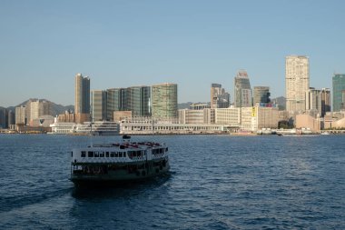 HONG KONG, ÇİN - 07 Aralık 2023: Victoria Limanı boyunca yolcu taşıyan bir yıldız feribotu. Star Ferry, Hong Kong 'da bir yolcu feribot operatörü ve turistik merkezdir..