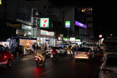 PHUKET, THAILAND - 25 Nisan 2023: Patong, Phuket 'te gece görüldüğü üzere 7-Eleven ve FamilyMart marketlerinin sokak manzarası.