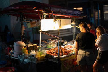PHUKET, THAILAND - 25 Nisan 2023: Patong, Phuket 'te gece görüldüğü gibi sokak yiyecek satıcısı.