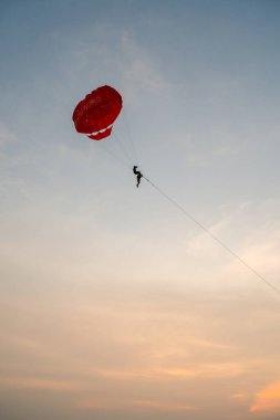 PHUKET, THAILAND - APRIL 20, 2023: paraskiing in Patong Beach in the evening clipart