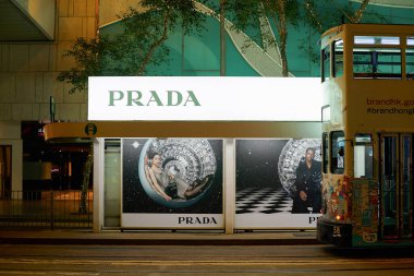 HONG KONG, ÇİN - 05 Aralık 2023 'te Central District' te gece vakti tramvay durağında görülen Prada reklam posterleri.