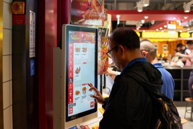 HONG KONG, ÇİN - 05 Aralık 2023: bir adam Hong Kong KFC 'de self-servis büfesi kullanır.