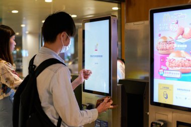HONG KONG, ÇİN - 05 Aralık 2023: Bir adam Hong Kong 'daki McDonald' s fast-food restoranında self servis büfesi kullanıyor..