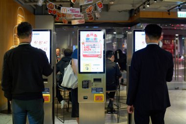 HONG KONG, ÇİN - 05 Aralık 2023: Erkekler Hong Kong 'daki McDonald' s fast-food restoranında self-servis büfelerini kullanır.