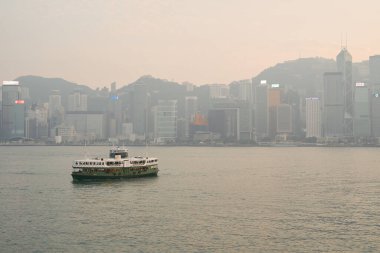 HONG KONG, CHINA - DECEMBER 05, 2023: a Star Ferry crossing Victoria Harbour. The Star Ferry is a passenger ferry service operator and tourist attraction in Hong Kong. clipart