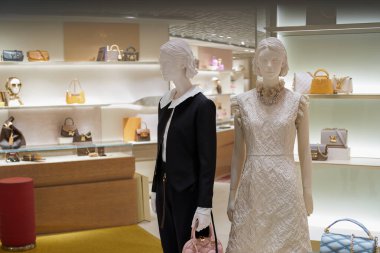 Hong Kong Uluslararası Havalimanı 'ndaki Louis Vuitton mağazasında giysili mankenler sergileniyor. Louis Vuitton, Fransız lüks moda evi..