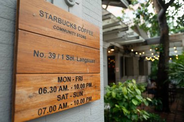 BANGKOK, THAILAND - 27 Ekim 2023: Bangkok 'taki Starbucks Coffee' de çalışma saatleri tabelalarının yakın plan çekimi.