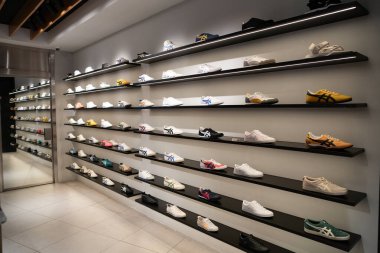 KUALA LUMPUR, MALAYSIA - 15 Mart 2023: Kuala Lumpur 'daki Suria KLCC alışveriş merkezindeki Onitsuka Tiger mağazasının iç çekimi.