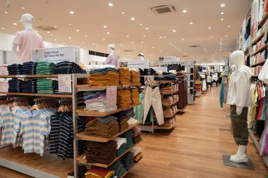 KUALA LUMPUR, MALAYSIA - 15 Mart 2023: Kuala Lumpur 'daki Uniqlo mağazasında satılık çeşitli giysiler