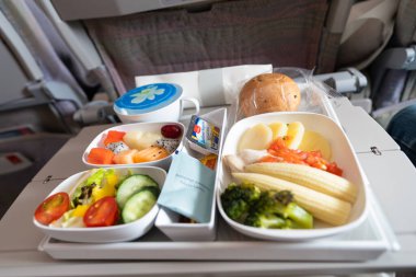 BANGKOK, THAILAND - HAZİRAN 09, 2019: Emirates A380-800 Ekonomi Sınıfı 'nda yemek servisi. Emirlikler, Birleşik Arap Emirlikleri 'nin kaliteli hizmet sunan iki bayrak taşıyıcısından biri..