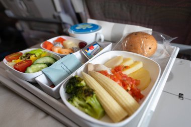BANGKOK, THAILAND - HAZİRAN 09, 2019: Emirates A380-800 Ekonomi Sınıfı 'nda yemek servisi. Emirlikler, Birleşik Arap Emirlikleri 'nin kaliteli hizmet sunan iki bayrak taşıyıcısından biri..