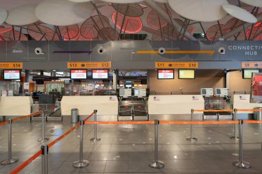 KUALA LUMPUR, MALAYSIA - NOVEMBER 14, 2023: check-in counters at KLIA2. Check-in involves passengers interacting with airline staff to verify documents, check luggage, and receive boarding passes. clipart