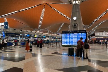 KUALA LUMPUR, MALAYSIA - 15 Kasım 2023: KLIA kontrol bölgesi. Kayıt işlemlerinde, havayolu personeli ile iletişim halinde olan yolcular belgelerini doğrulamak, bagajlarını kontrol etmek ve uçuş kartı almak için bulunurlar..