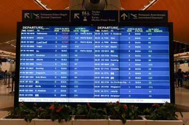 KUALA LUMPUR, MALAYSIA - NOVEMBER 15, 2023: FIDS at the departure level in KLIA. Flight Information Display System that shows real-time flight details such as departures, gate numbers, and delays. clipart