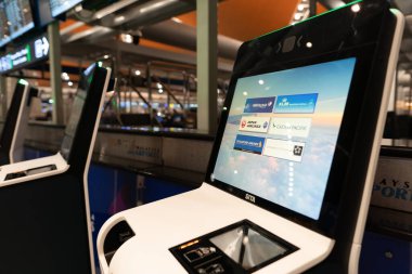 KUALA LUMPUR, MALAYSIA - NOVEMBER 22, 2023: self check-in area at KLIA. Self check-in is a process where passengers use a kiosk to check in and print boarding passes themselves. clipart