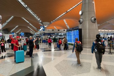 KUALA LUMPUR, MALAYSIA - 22 Kasım 2023: KLIA kontrol bölgesi. Kayıt işlemlerinde, havayolu personeli ile iletişim halinde olan yolcular belgelerini doğrulamak, bagajlarını kontrol etmek ve uçuş kartı almak için bulunurlar..