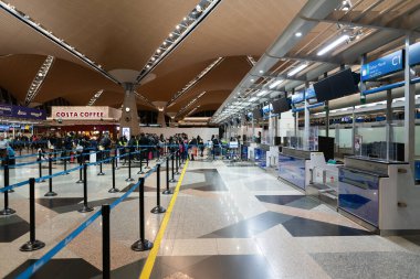 KUALA LUMPUR, MALAYSIA - 22 Kasım 2023: KLIA kontrol bölgesi. Kayıt işlemlerinde, havayolu personeli ile iletişim halinde olan yolcular belgelerini doğrulamak, bagajlarını kontrol etmek ve uçuş kartı almak için bulunurlar..